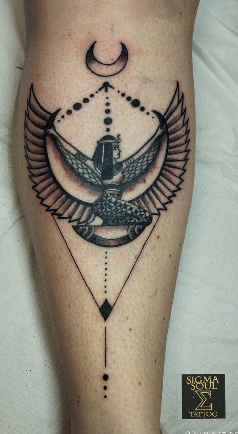 Tatuaje en negro de la diosa Isis con alas abiertas, luna creciente, dotwork y elementos geométricos en el gemelo, realizado en Sigma Soul Tattoo (Carmona, Sevilla).