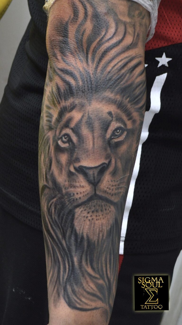 Tatuaje realista en black & grey de un león en el antebrazo, con melena detallada y mirada intensa, realizado en Sigma Soul Tattoo (Carmona, Sevilla).