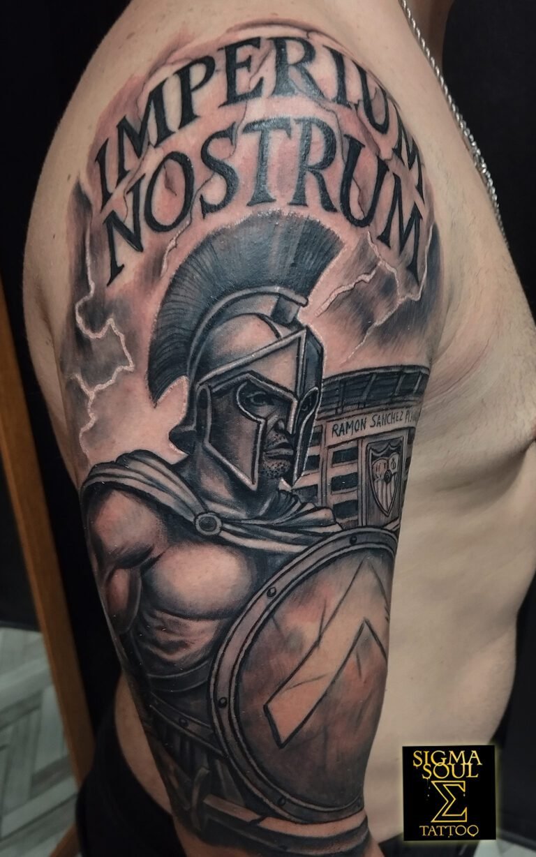 Tatuaje realista en black & grey de un guerrero romano/espartano con escudo, casco y la frase “Imperium Nostrum”, acompañado del estadio Ramón Sánchez-Pizjuán. Realizado en Sigma Soul Tattoo en Carmona – Sevilla.