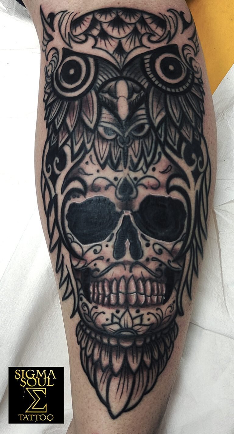 l símbolo que observa. Esta pieza fusiona dos arquetipos poderosos: la calavera, emblema del paso y la trascendencia, y el búho, guardián del conocimiento y la intuición. Unidos, crean una figura que representa lucidez ante lo inevitable. No hay miedo en la mirada, solo presencia. El diseño trabaja con negro sólido, líneas gruesas y un ritmo ornamental que recuerda el arte ritual. La geometría del búho refuerza la sensación de vigilancia, mientras la calavera aporta la fuerza terrenal. Cada trazo mantiene intención: contraste, simetría y energía. El resultado es una pieza que habla de equilibrio entre sabiduría y oscuridad, entre razón y misterio. En Sigma Soul Tattoo, cada composición busca eso: impacto visual, significado y coherencia estética. Explora más en sigmasoultattoo.com o contáctanos por WhatsApp al 640 119 066 para planificar tu próxima obra.
