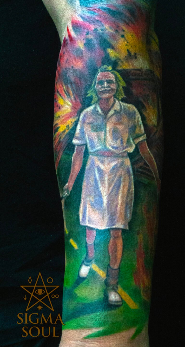 Belleza en medio del caos. Este tatuaje representa una de las imágenes más potentes del cine contemporáneo: el Joker avanzando con calma mientras el mundo estalla detrás. Es una metáfora visual de la mente que ya no teme al colapso y encuentra serenidad dentro del fuego. Los colores vibran en conflicto: el blanco del uniforme frente a la explosión que lo rodea. Verdes, amarillos y rojos se funden en un estallido controlado, como si la locura tuviera su propio orden. La composición y los contrastes de luz convierten el caos en algo hipnótico, cargado de energía y equilibrio. En Sigma Soul Tattoo cada pieza se diseña como una obra cinematográfica: con intención, ritmo y emoción visual. Este tatuaje celebra la libertad interior, el coraje y la elegancia del descontrol. Reserva tu cita en sigmasoultattoo.com o escríbenos por WhatsApp al 640 119 066